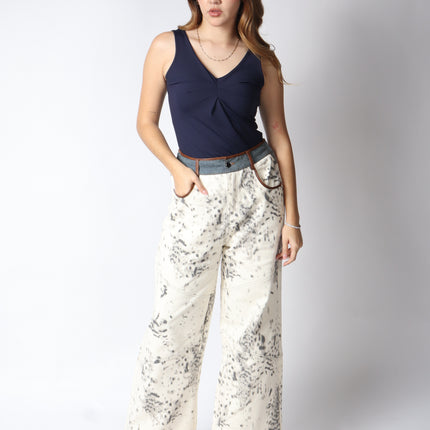 Pantalón de mezclilla beige con detalles en gris.