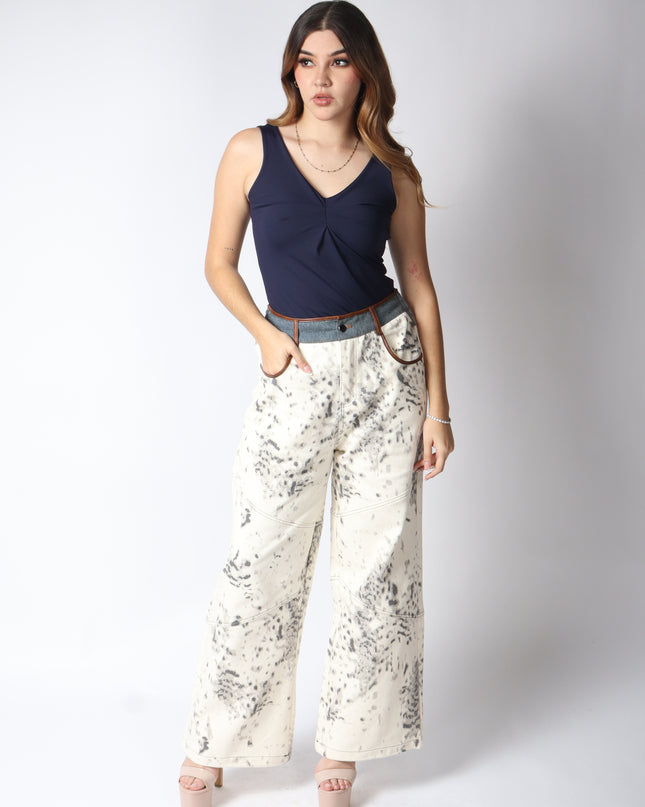 Pantalón de mezclilla beige con detalles en gris.