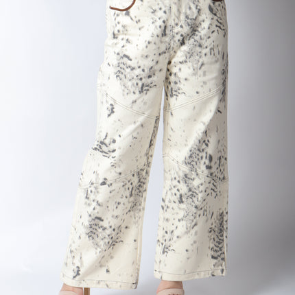 Pantalón de mezclilla beige con detalles en gris.