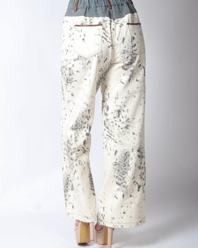 Pantalón de mezclilla beige con detalles en gris.